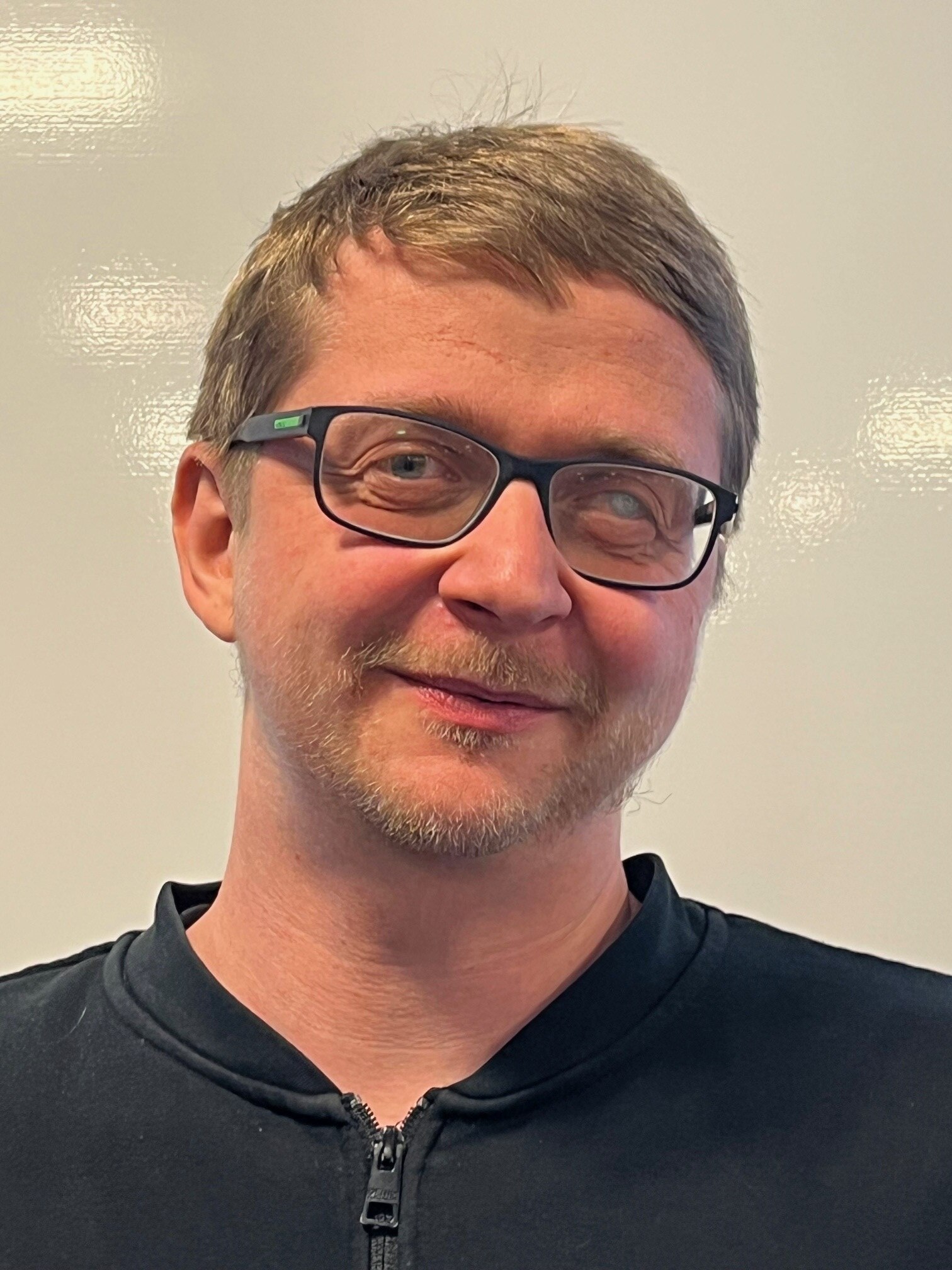 Mann mit kurzen dunkelblonden Haaren und Brille