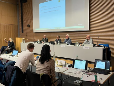 Blick auf das Podium mit vier Rednern mit Blick zur Hörerschaft